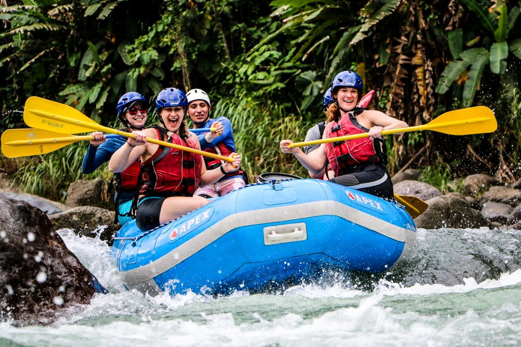 Пять человек на плоту вместе плывут по бурной реке в Коста-Рике.