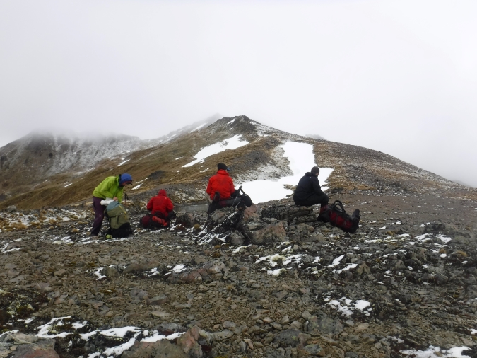 4 студента выпускного курса поднимаются на заснеженную гору с рюкзаком